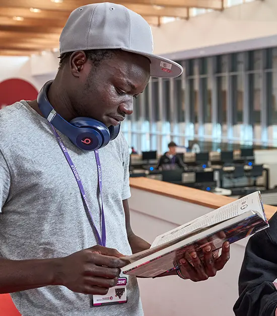 Student in library, studying a book